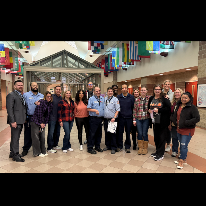 people standing and smiling for picture in brown hallway 