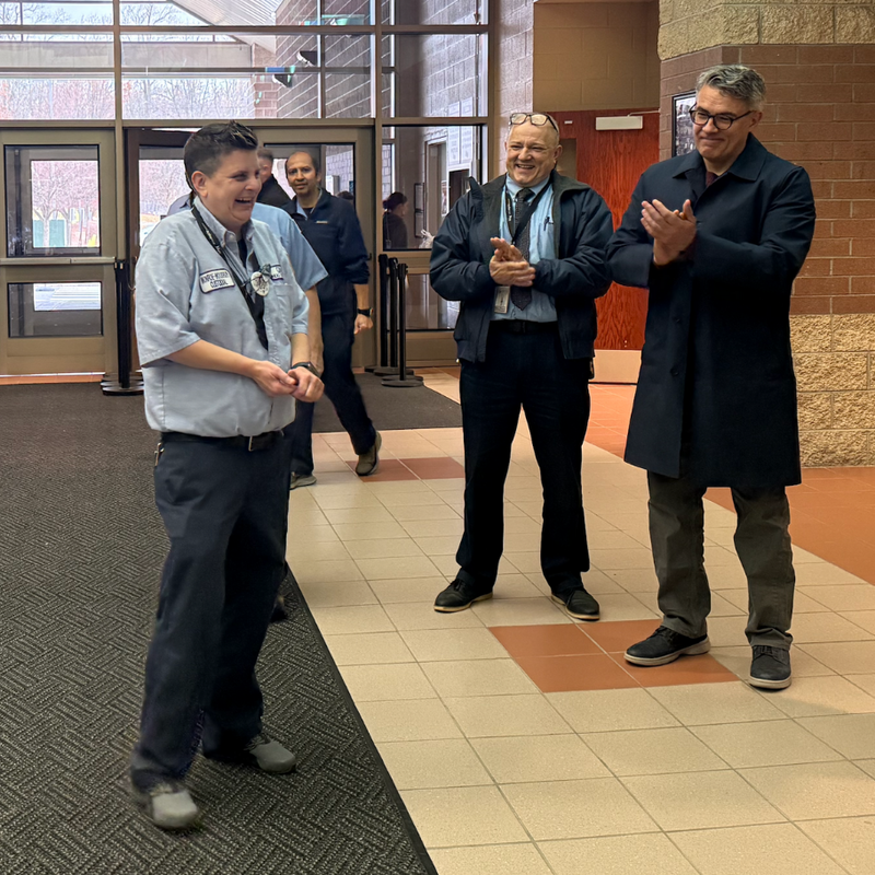 woman in blue shirt smiling in brownhallway