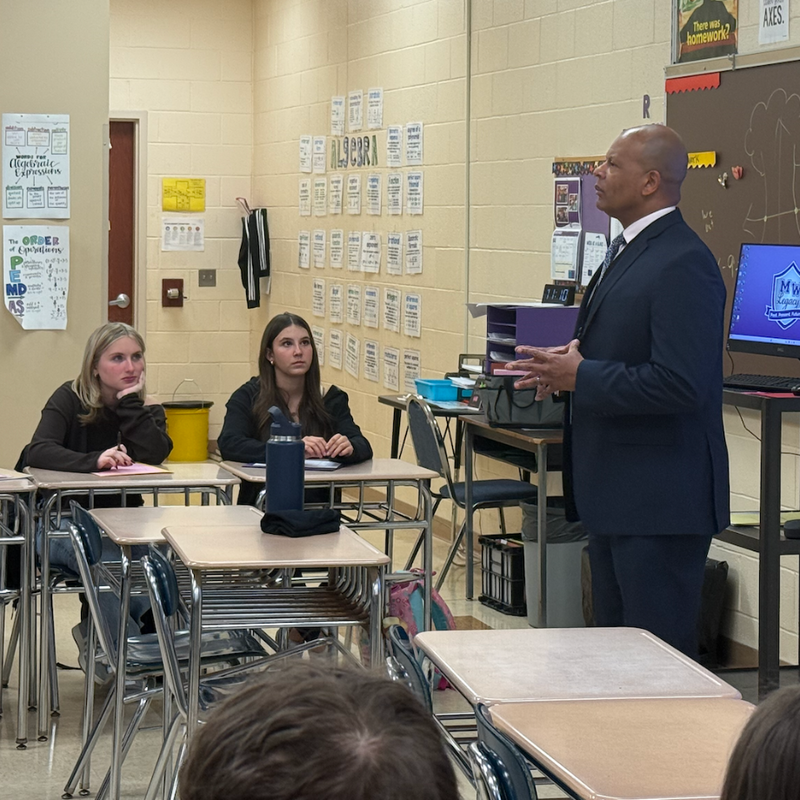 man standing with blue suit in classroom