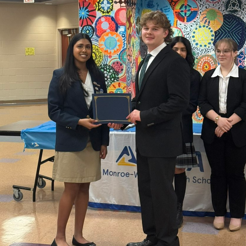 student holding blue certificate