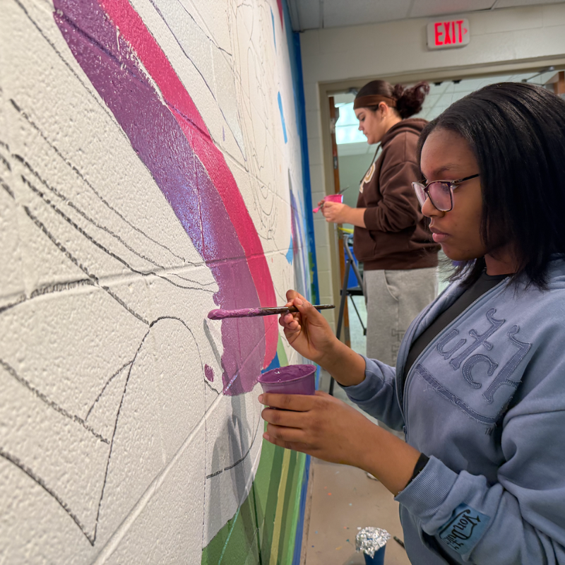 student holding a paint brush