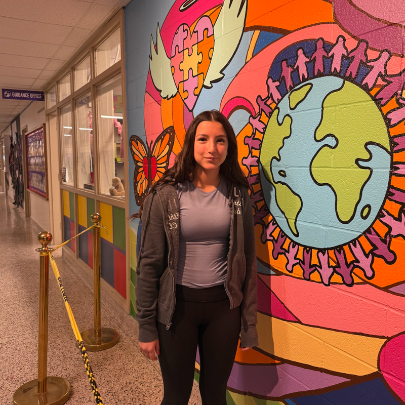 student standing next to a wall