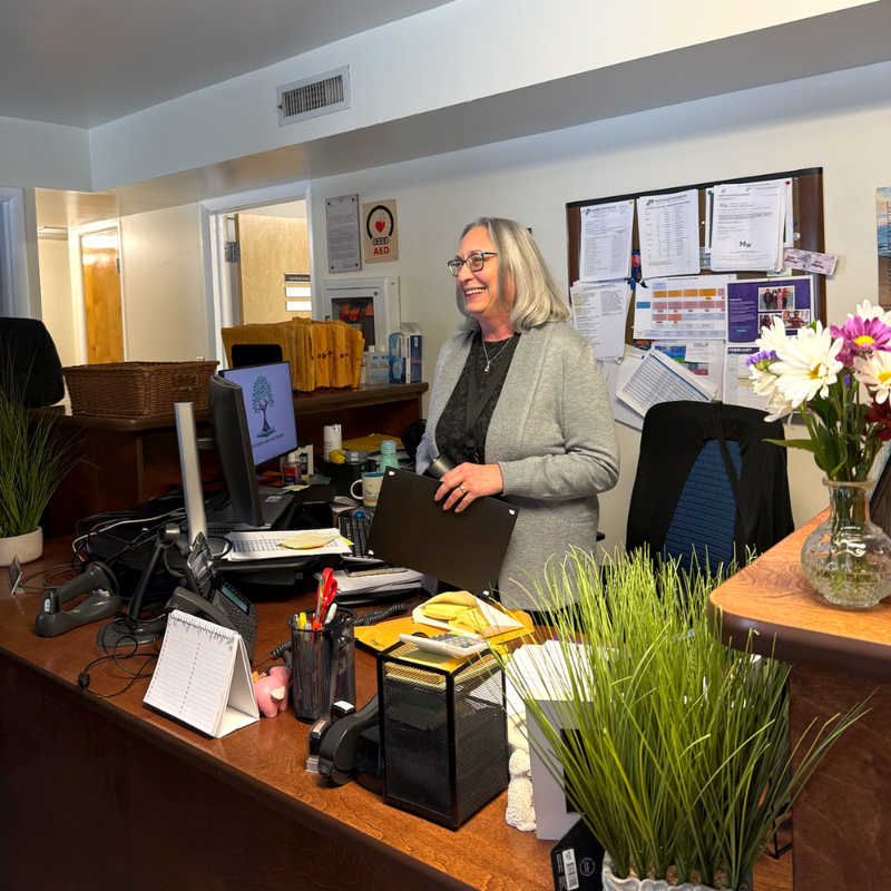 woman standing behind a desk 