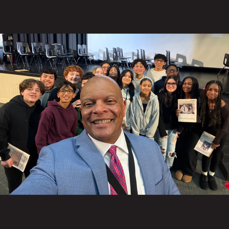 man standing with students in the back