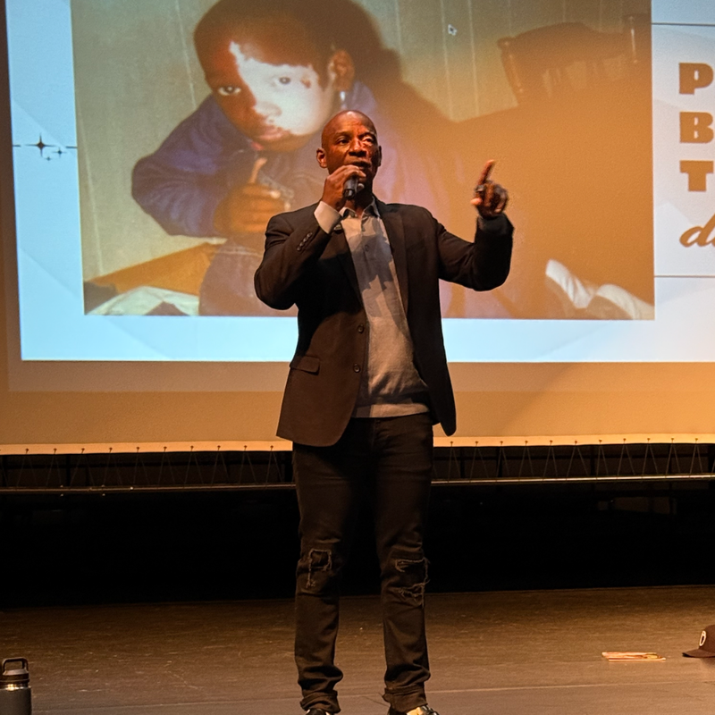 man standing on stage holding a microphone