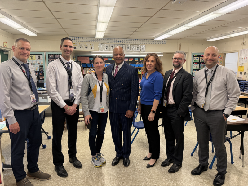 seven people standing in a classroom
