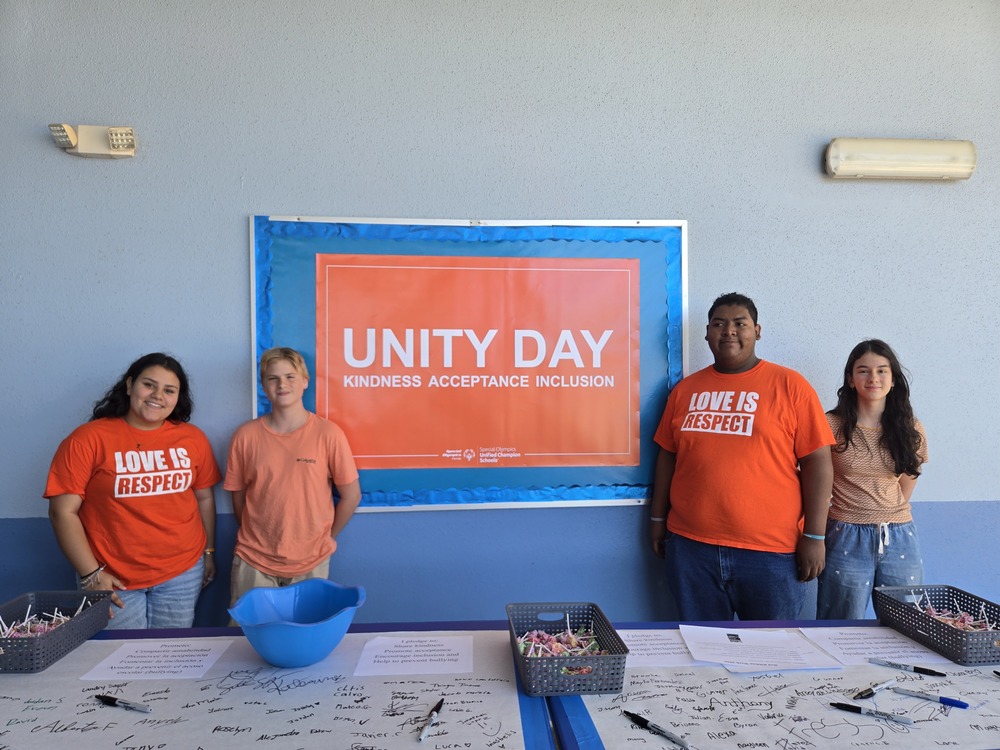 students posing in front of unity day backdrop