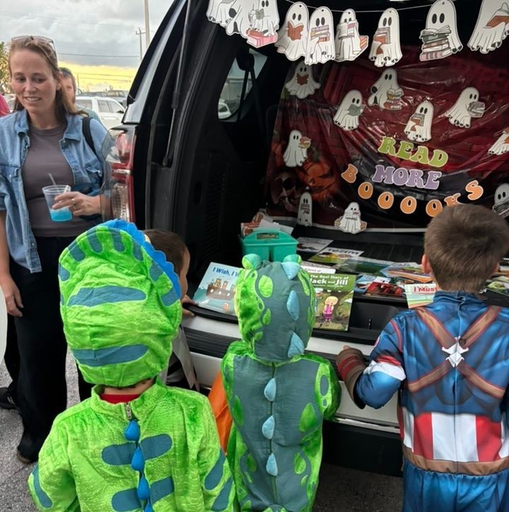 kids dressed up for Halloween choosing books