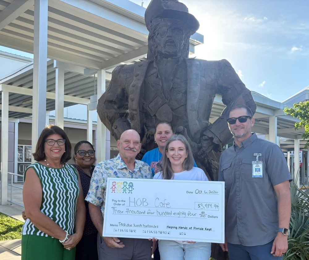 Group of people delivering a check to HOB School to pay for lunches for students