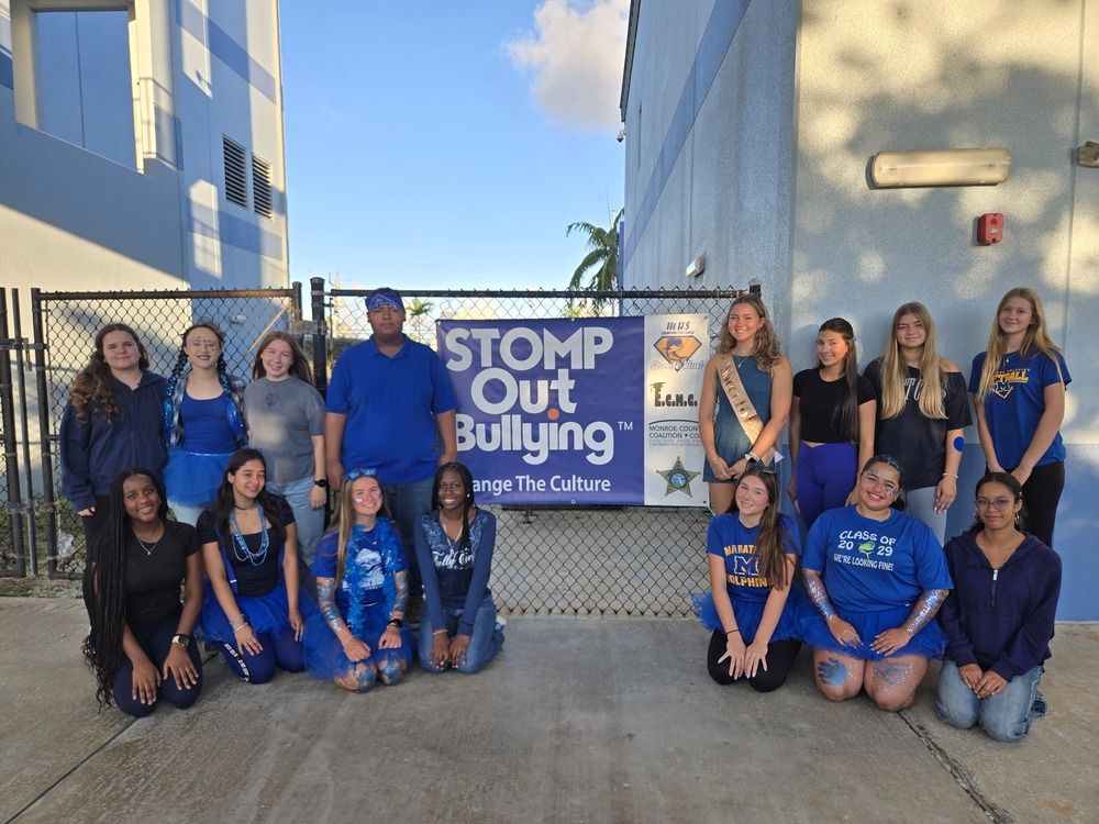 kids in blue in front of sign