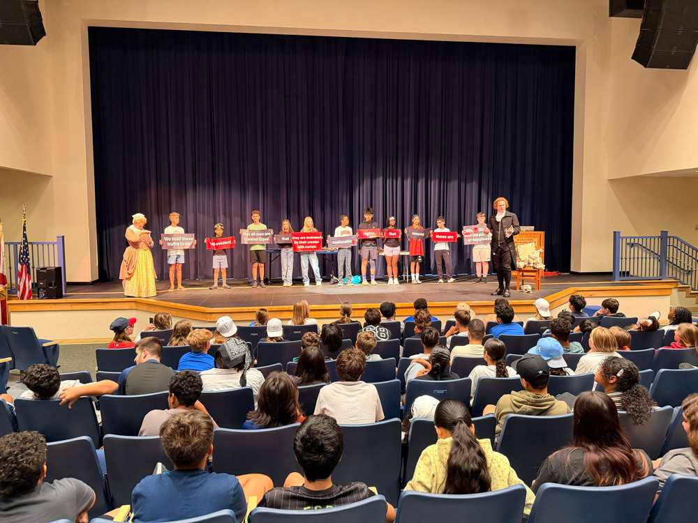 students presenting to other students in auditorium