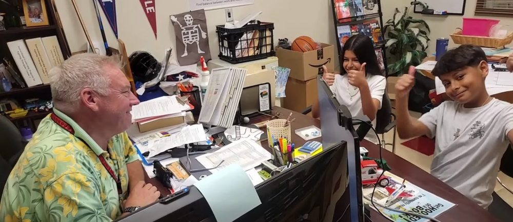 screen shot of video with two teens in front of an adult