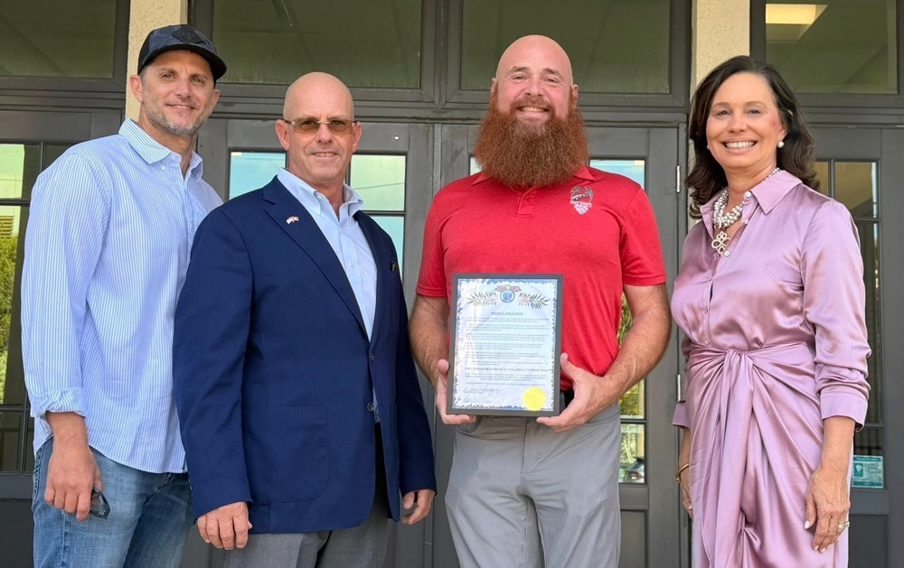 Hernandez displays his award with others around him