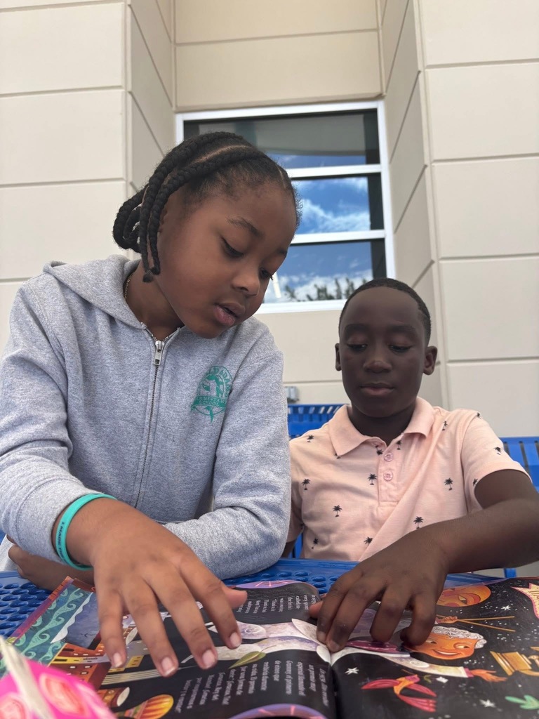 Fifth Grade student reading to a first grade student