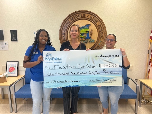 Keys Federal employees presenting principal paul with large check