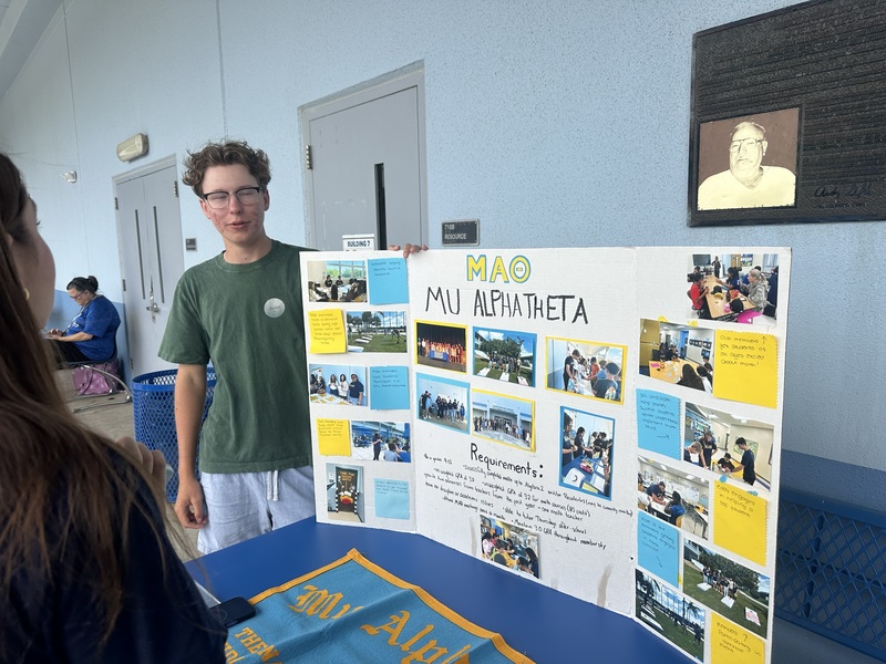 student standing next to display board