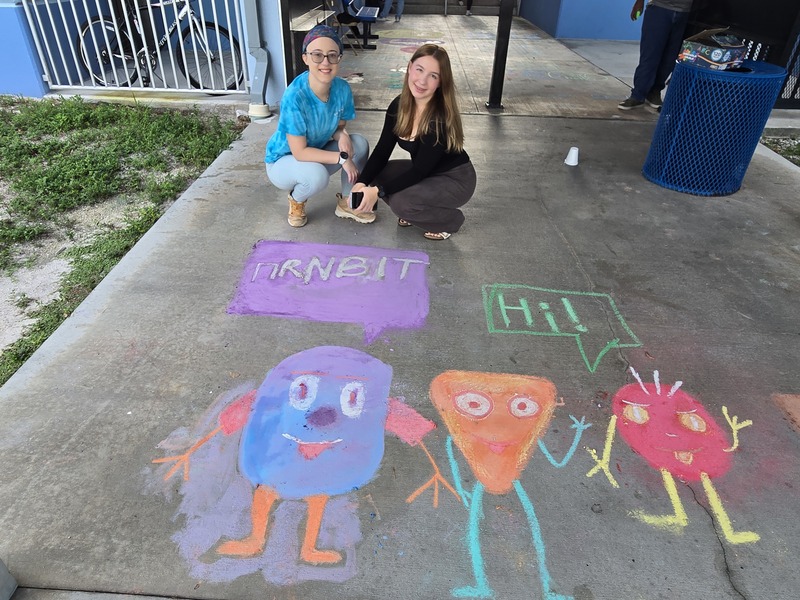 students drawing on sidewalk with chalk