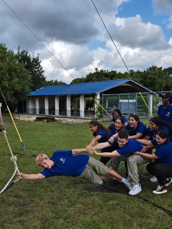 group of students poses at obstacle course