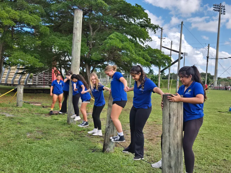 group of students poses at obstacle course
