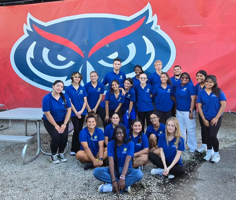 group of students poses at obstacle course