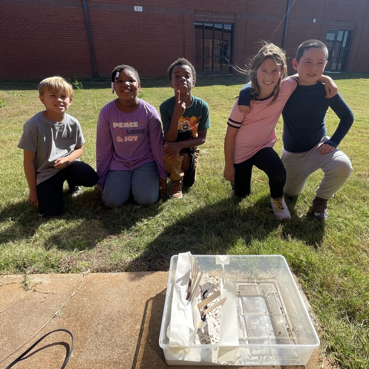 Students showing off the structure they built to protect peanut erosion