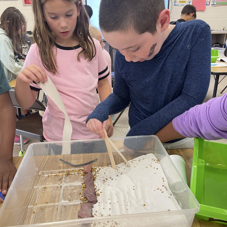 Students showing off the structure they built to protect peanut erosion