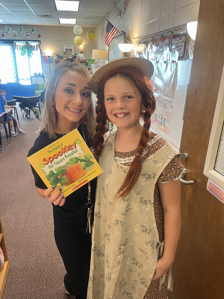 Student giving a teachers a book