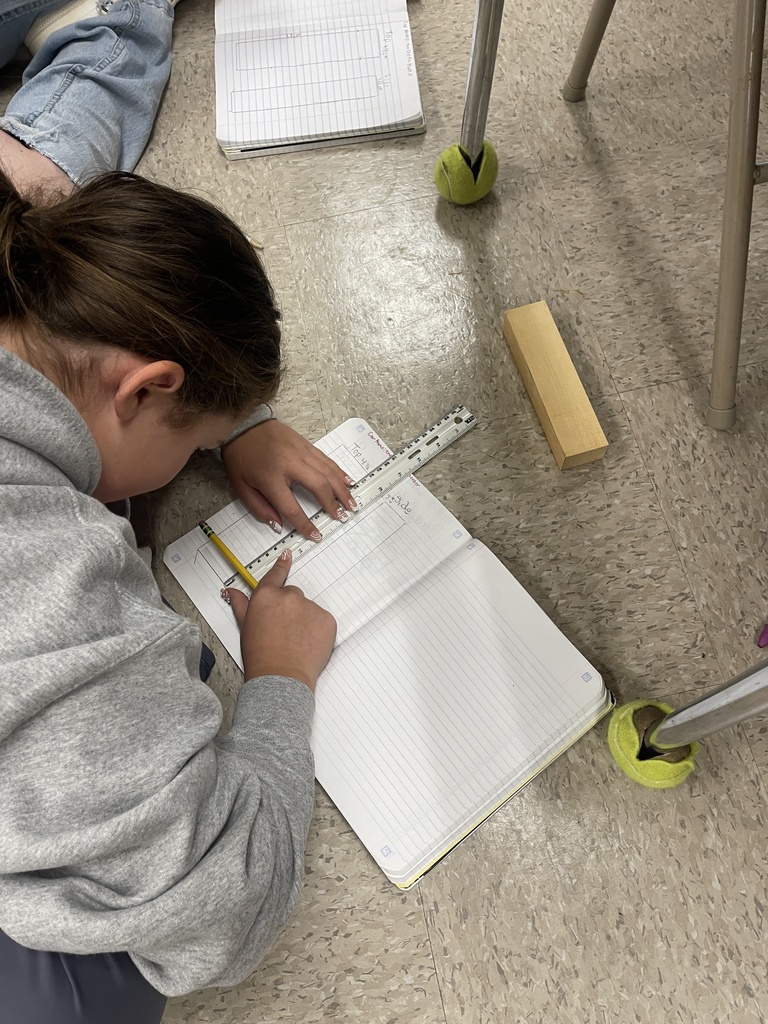 Students working on derby car designs in journal