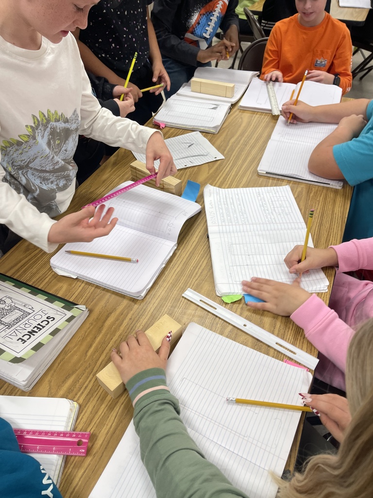 Students working on derby car designs in journal