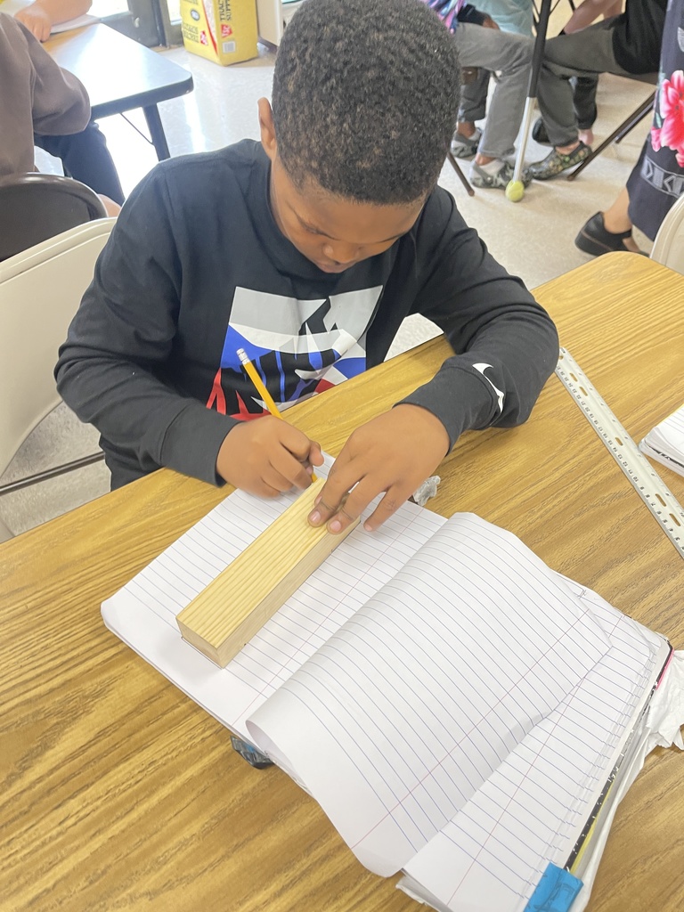 Students working on derby car designs in journal