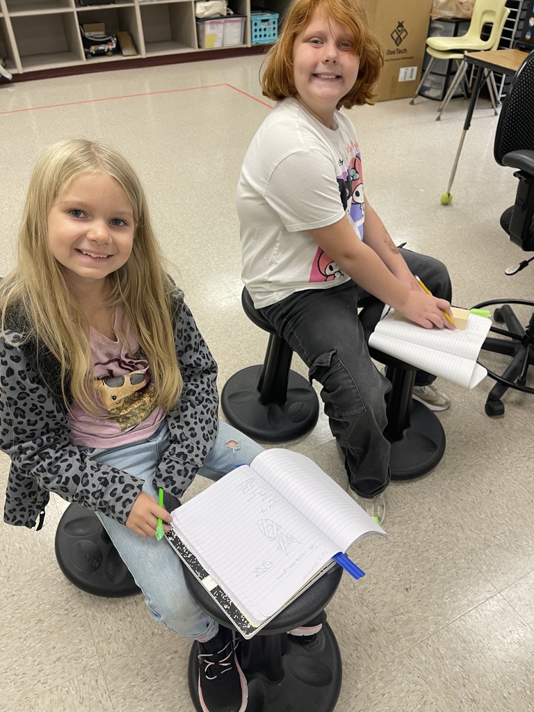 Students working on derby car designs in journal