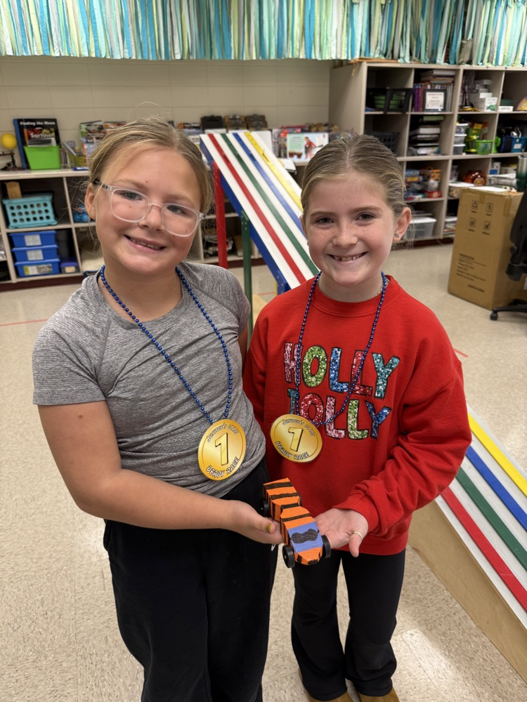 girls holding derby car