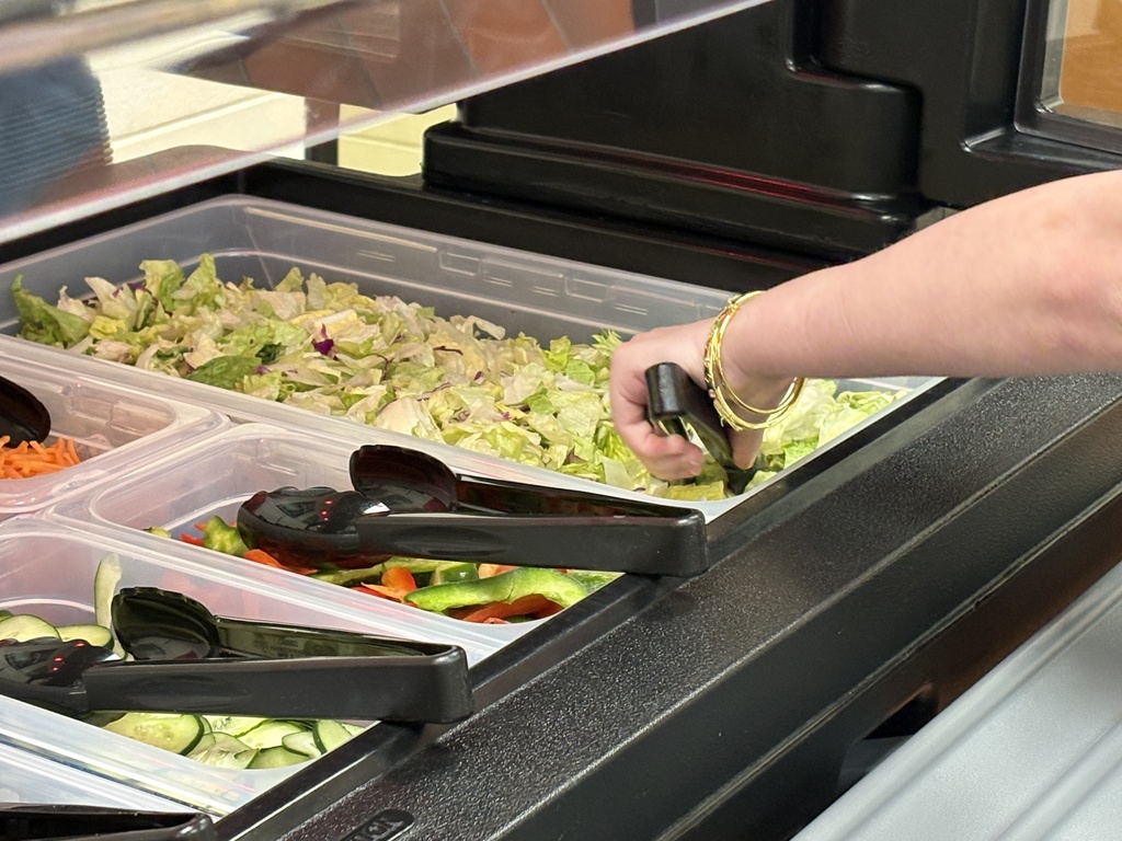 Student scooping lettuce