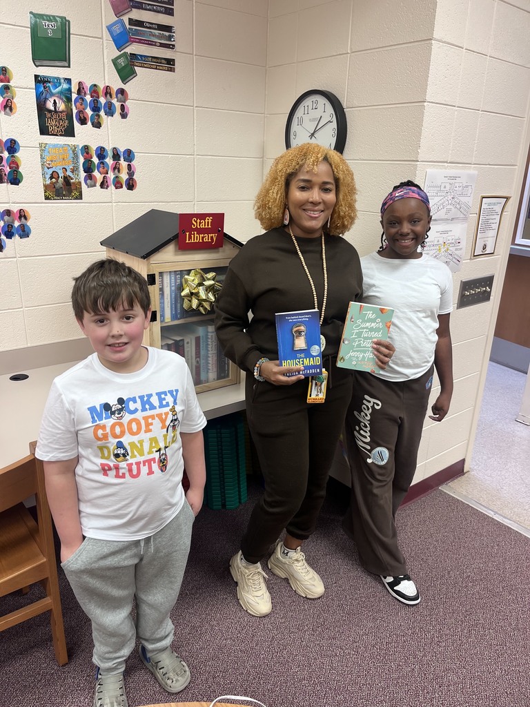 Team members and teachers in from of staff library