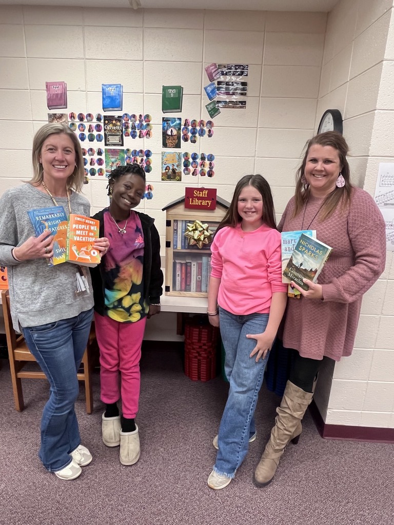 Team members and teachers in from of staff library