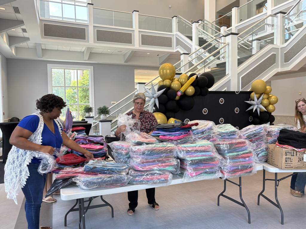 MCS staff unboxing backpacks