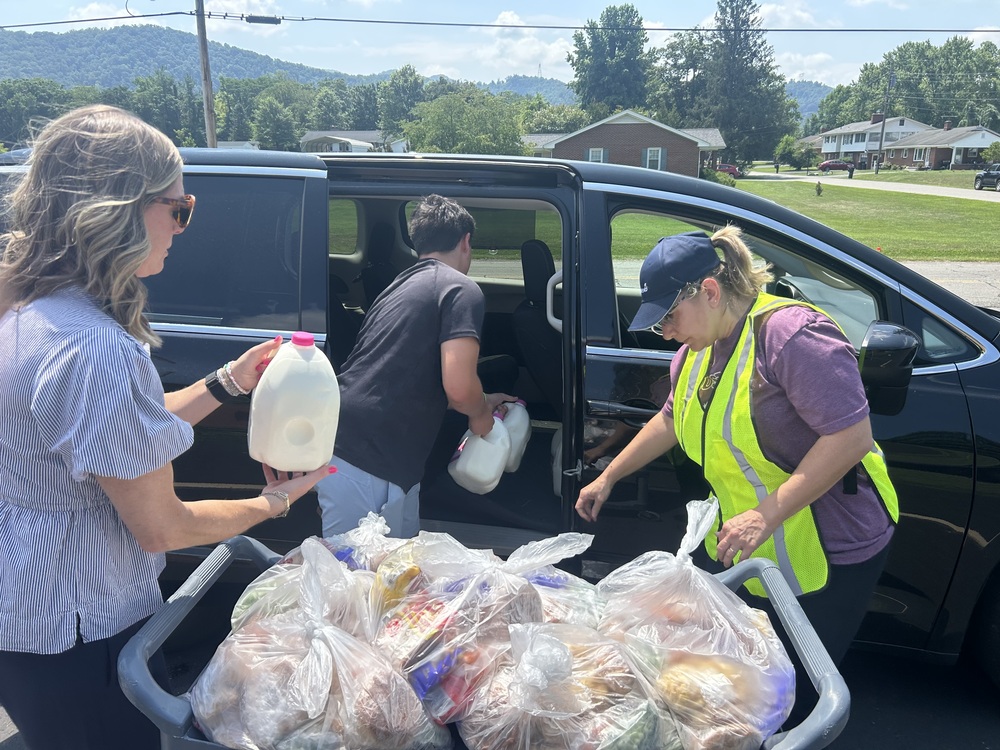 Gallons of milk being loaded into a car
