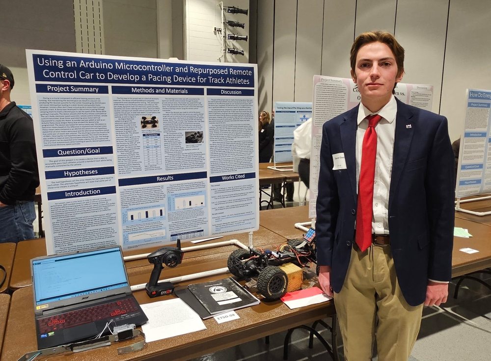 Photo of Spencer Sission standing in front of a project board