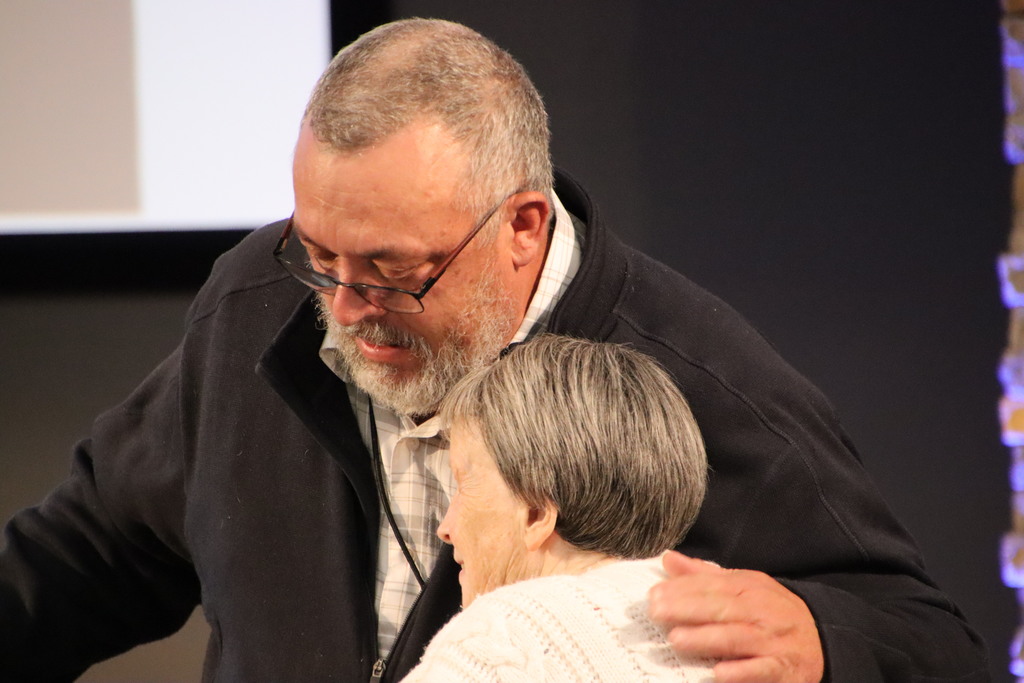 Man hugging woman at retirement dinner