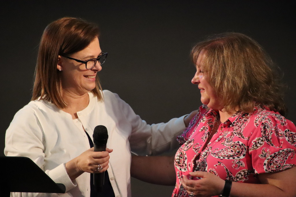 Woman smiling talking about another woman