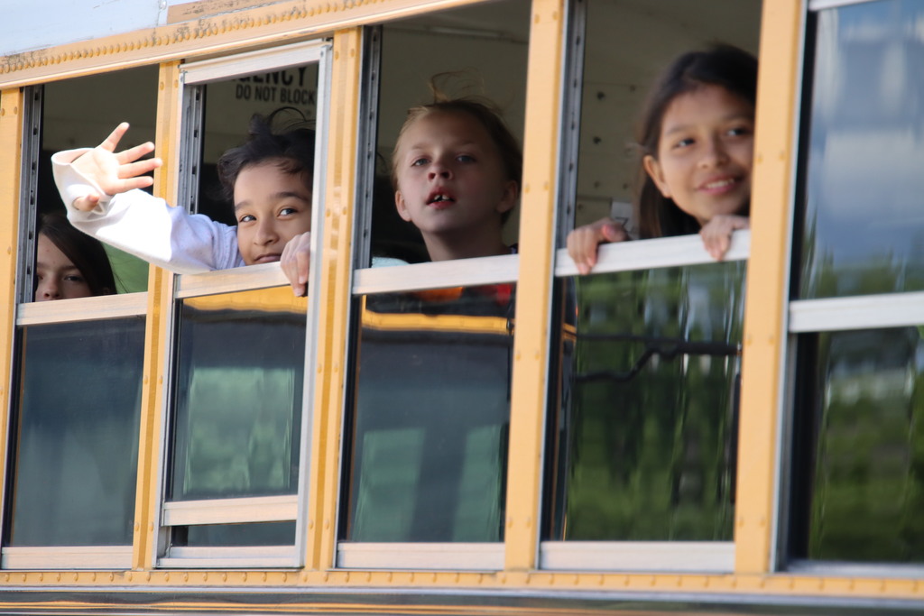 PFES students hanging out bus window waving