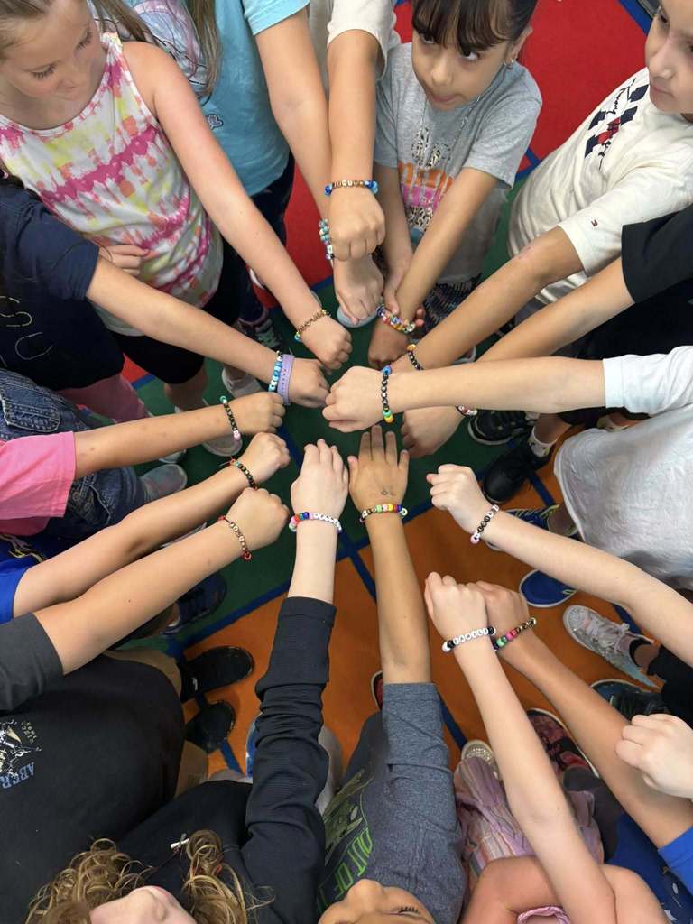 students with hands together showing off their bracelets