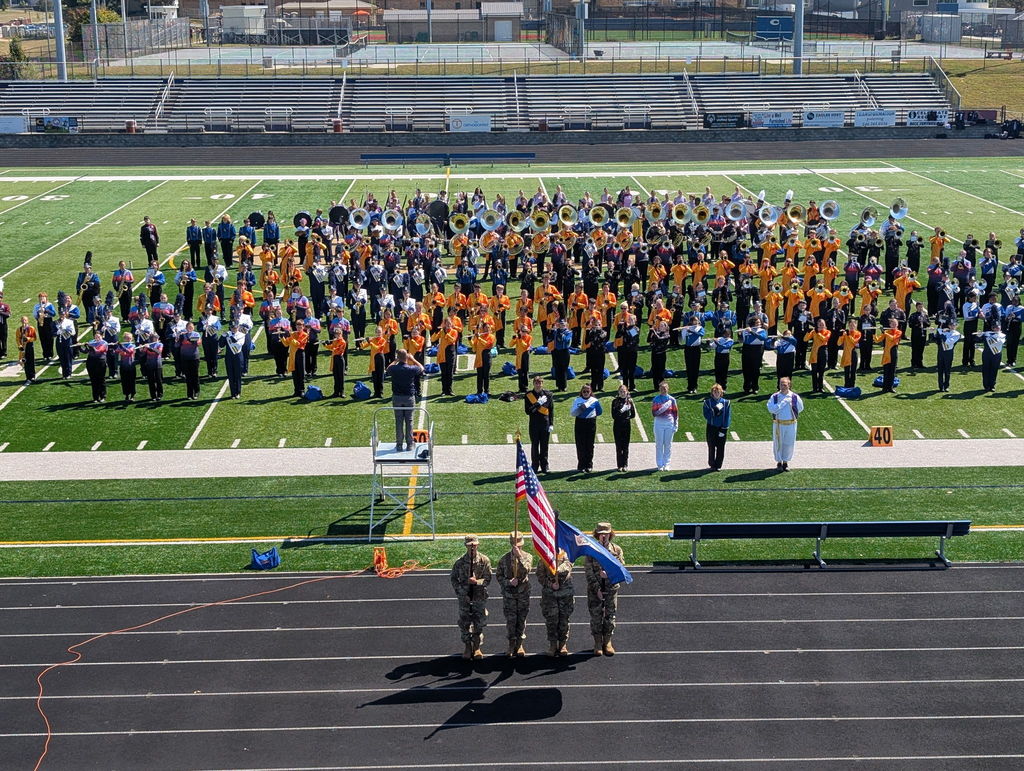 Members of all four MCPS marching bands playing on a football field. 