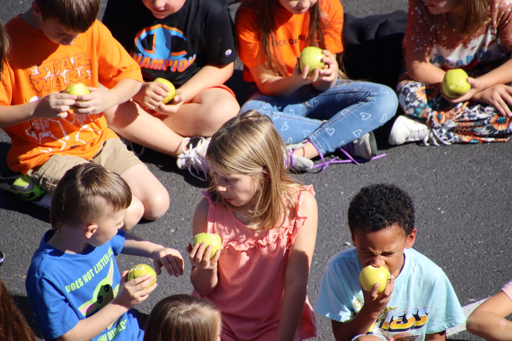 Students biting into an apple