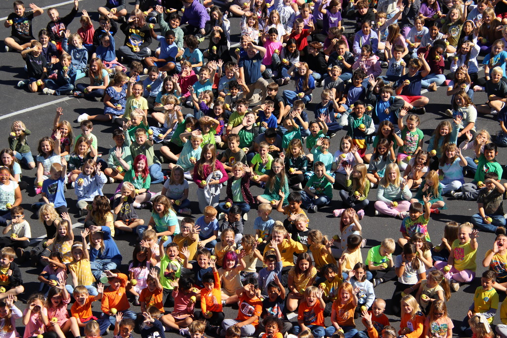 wide shot of the entire EMES student body sitting on pavement 
