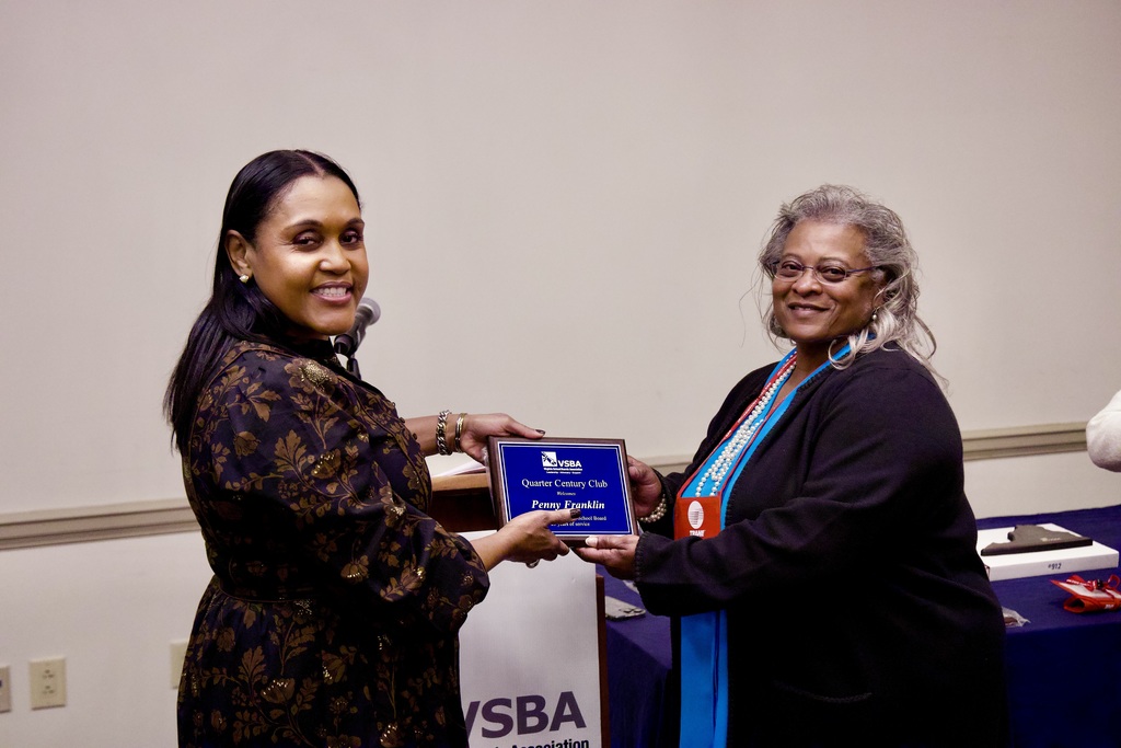 Penny Franklin posing for a photo with another woman while holding a plaque.