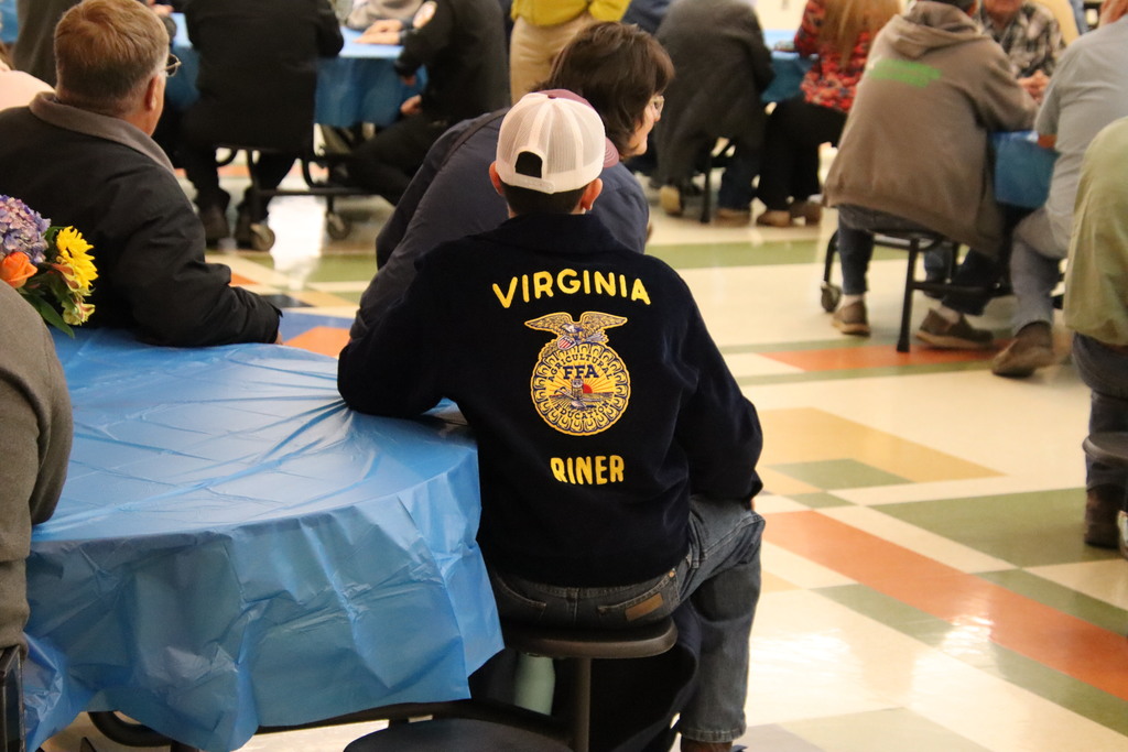 Close-up of the back of a navy blue Riner FFA corduroy jacket, highlighting the gold "Virginia" and "Riner" embroidery.