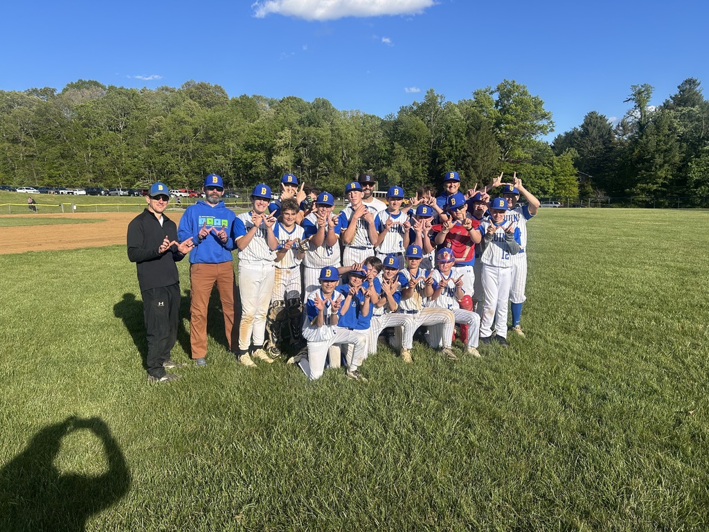 Baseball team members holding their hands in Ws to celebrate their win.