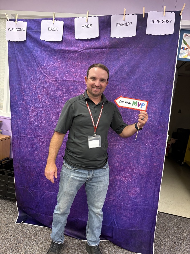 An HAES employee standing in front of a photo booth.