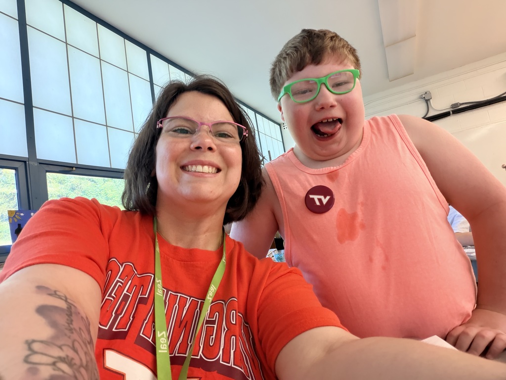Smiling teacher and student showing off their Virginia Tech colors and shirts